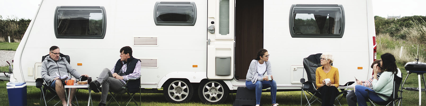 Group of people sitting outside a trailer